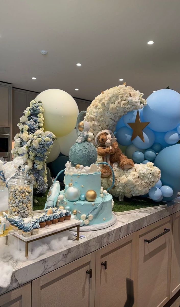 a table topped with lots of blue and white balloons