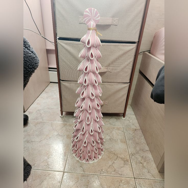 a pink christmas tree is sitting on the floor