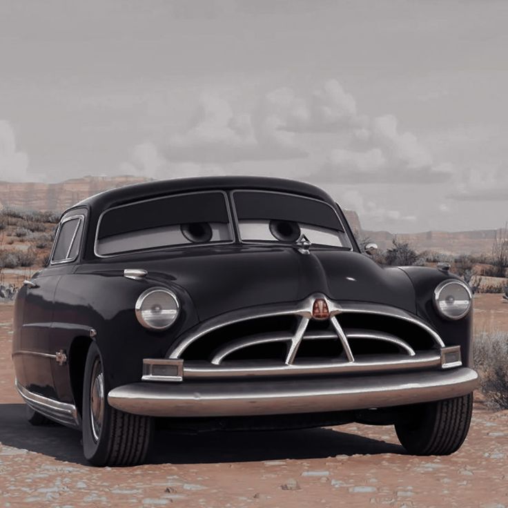 an old black car is parked in the desert