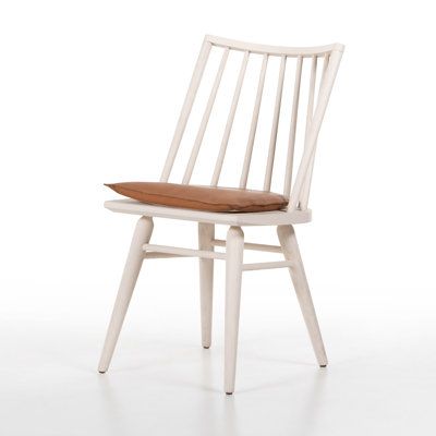 a white wooden chair with a brown cushion on it's seat and backrest