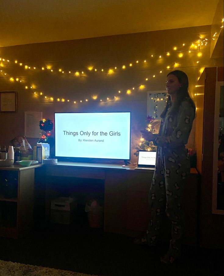 a woman standing in front of a flat screen tv with the words things only for the girls on it