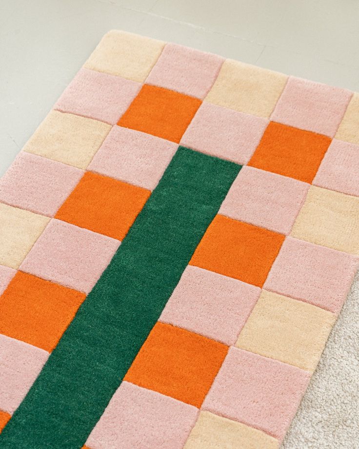 an orange, pink and green rug on the floor