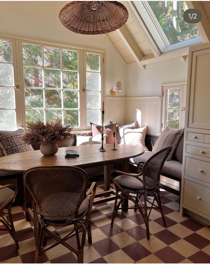 a dining room table and chairs in front of windows