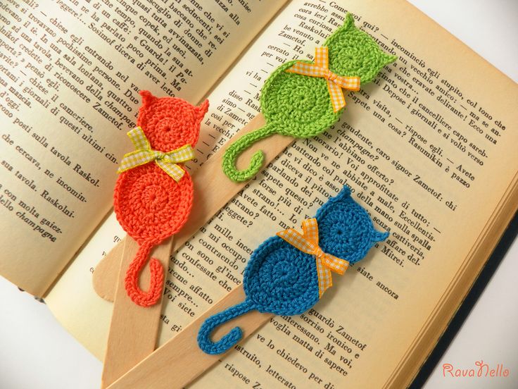 crocheted bookmarks with cats on them sitting on top of an open book