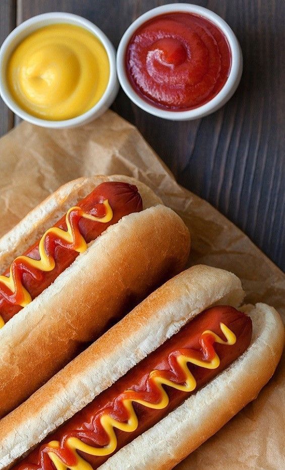 two hot dogs with ketchup and mustard on them