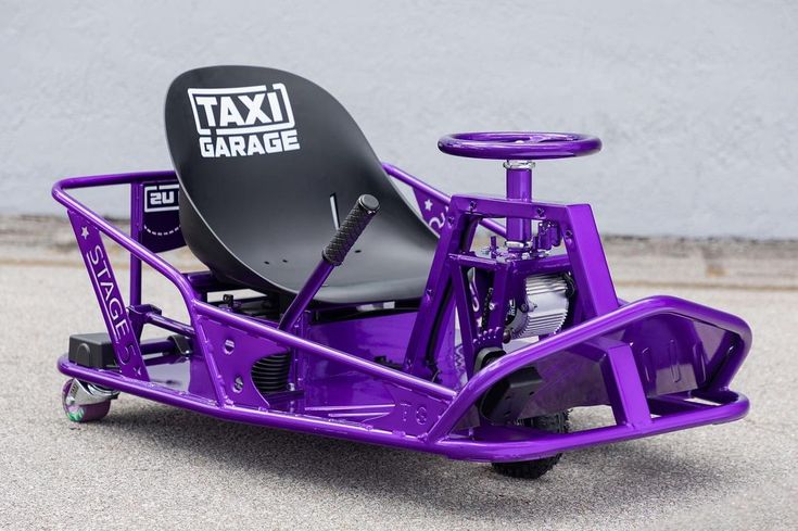 a purple cart with a black seat and an umbrella on the back that says taxi garage