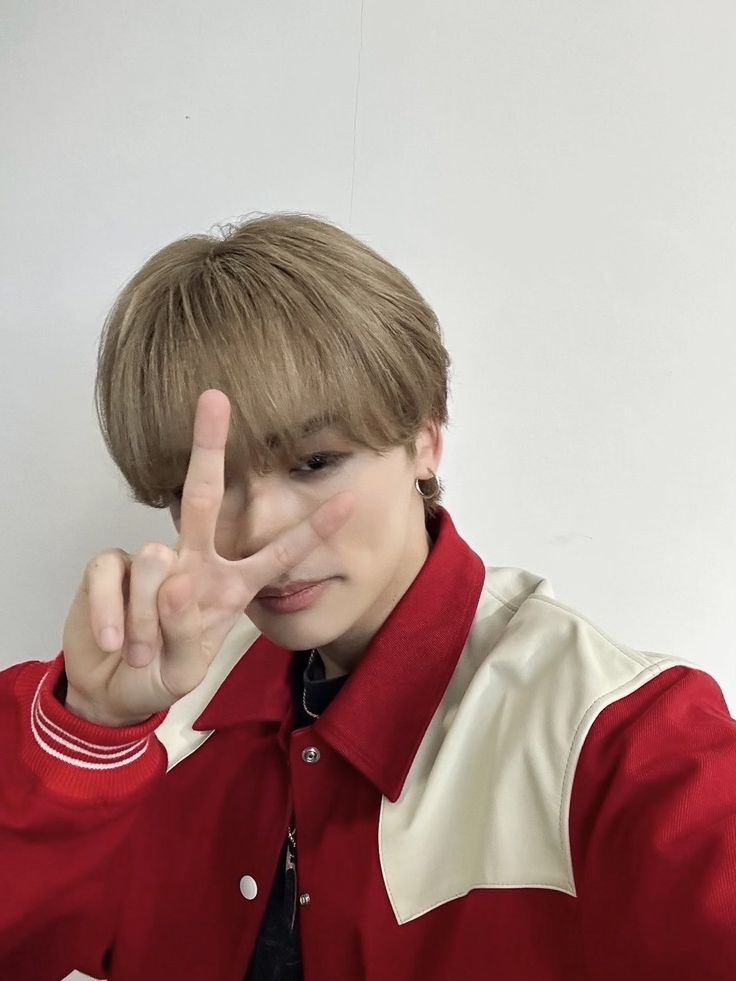 a boy making the peace sign with his fingers