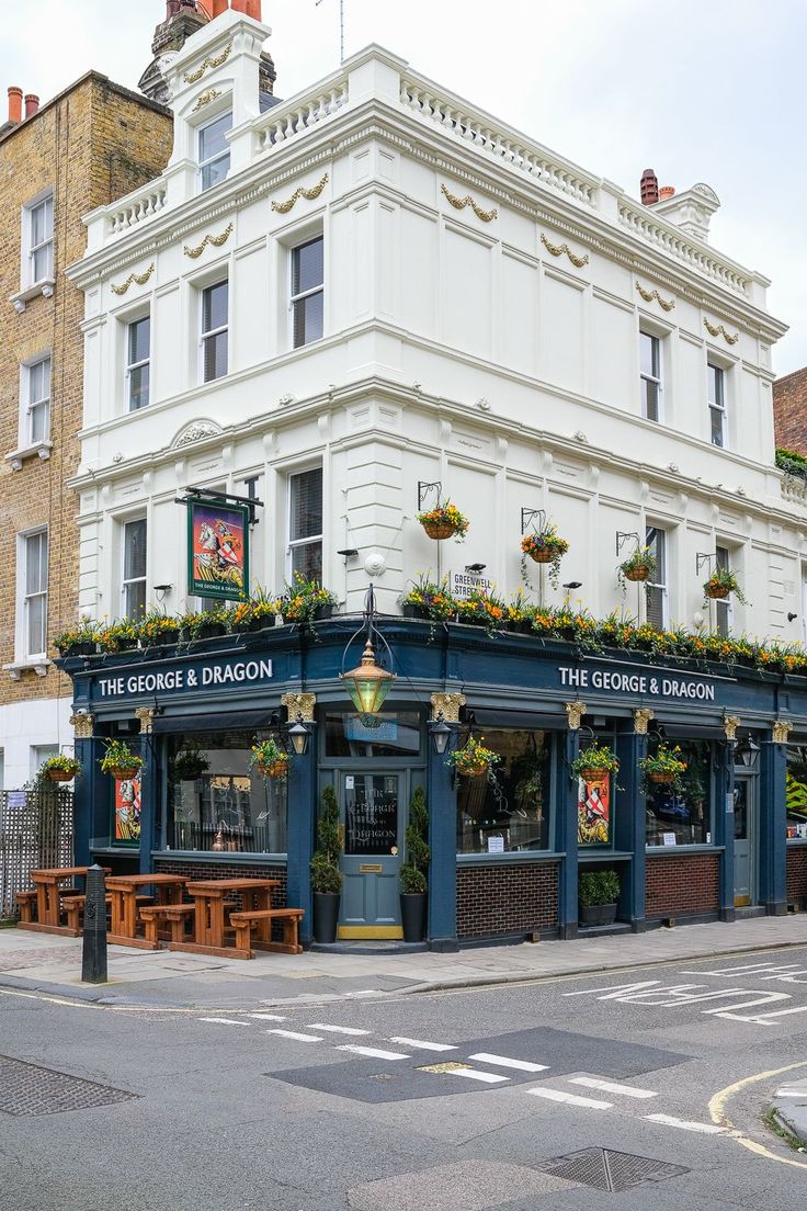 the corner and dragon pub in london is blue with plants growing on it's roof