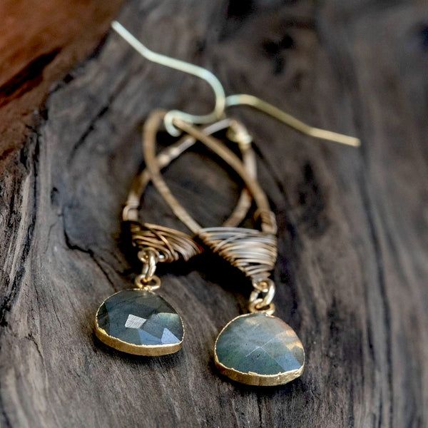 a pair of earrings sitting on top of a wooden table