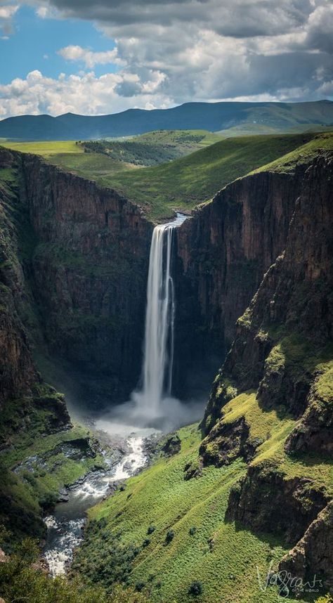 a large waterfall in the middle of a valley