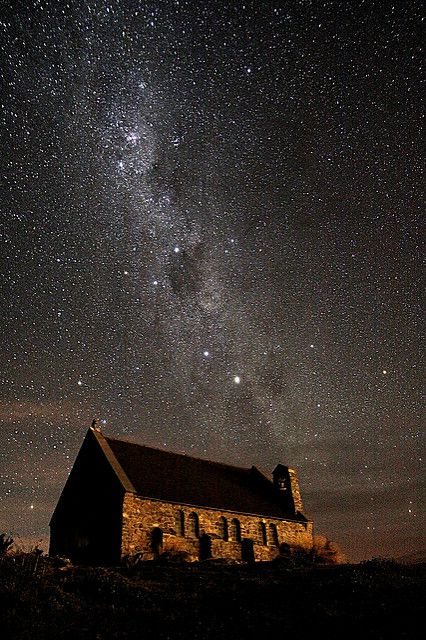 the night sky is filled with stars above an old church