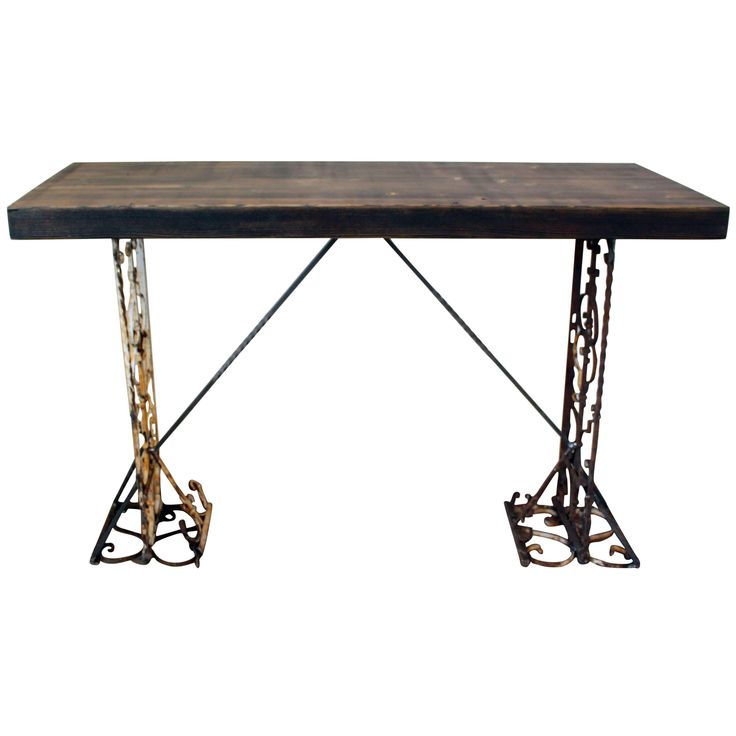 an iron and wood table with two legs on each side, one leg raised up to the