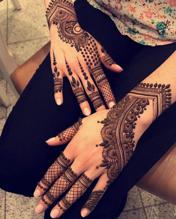 a woman's hands with henna tattoos on them