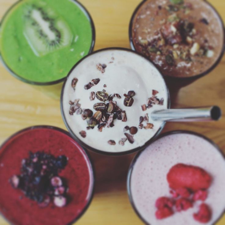 four different types of smoothies in cups on a table