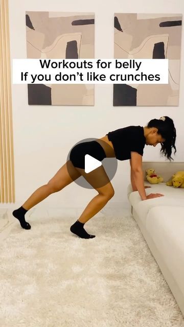 a woman is doing exercises on the floor in front of a couch with her legs spread out