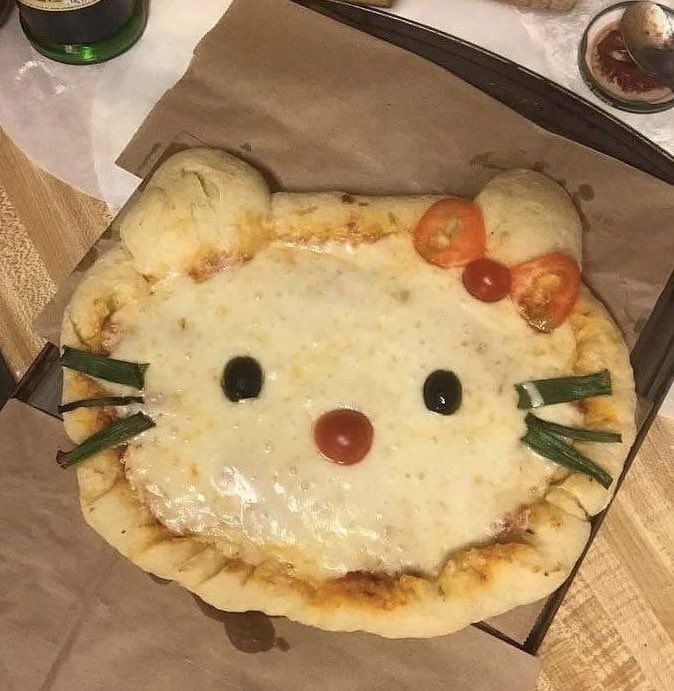 a hello kitty pizza with tomatoes and cheese on it