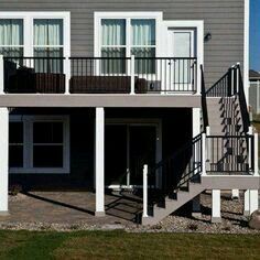 a two story house with white balconies and black railings