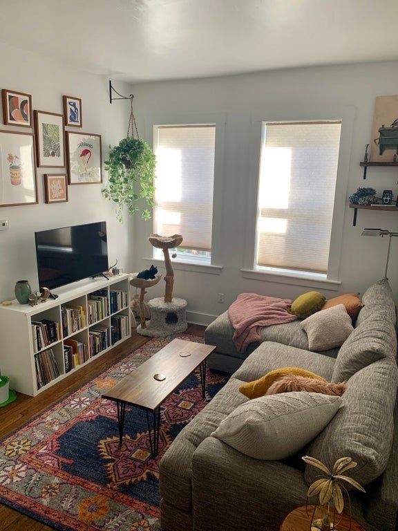 a living room filled with furniture and a flat screen tv on top of a wooden table