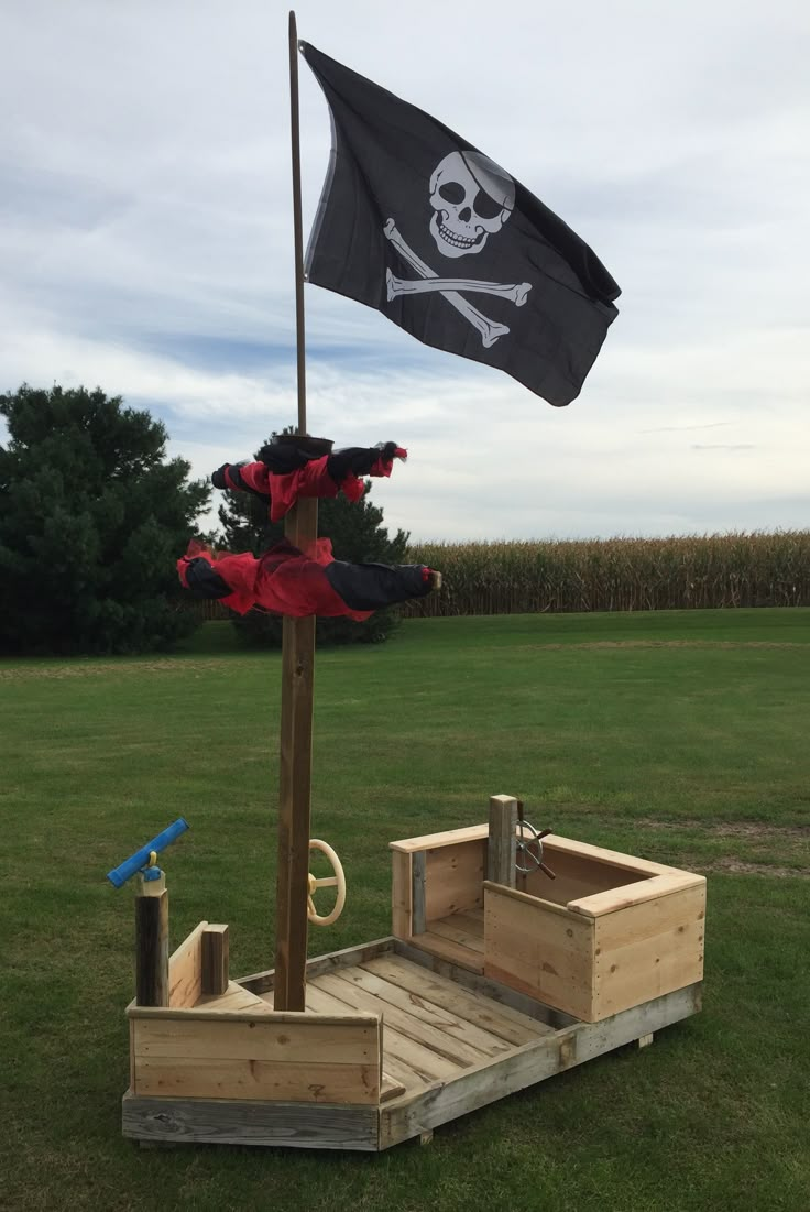 a pirate ship made out of pallets with a flag on top and an umbrella