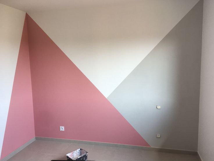 an empty room with pink and white paint on the walls, carpeted flooring