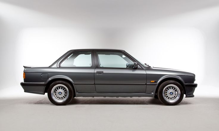 a grey car parked in a white room