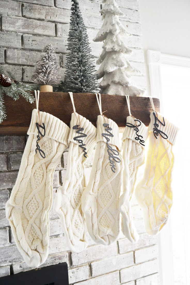 stockings hanging from a fireplace with christmas decorations