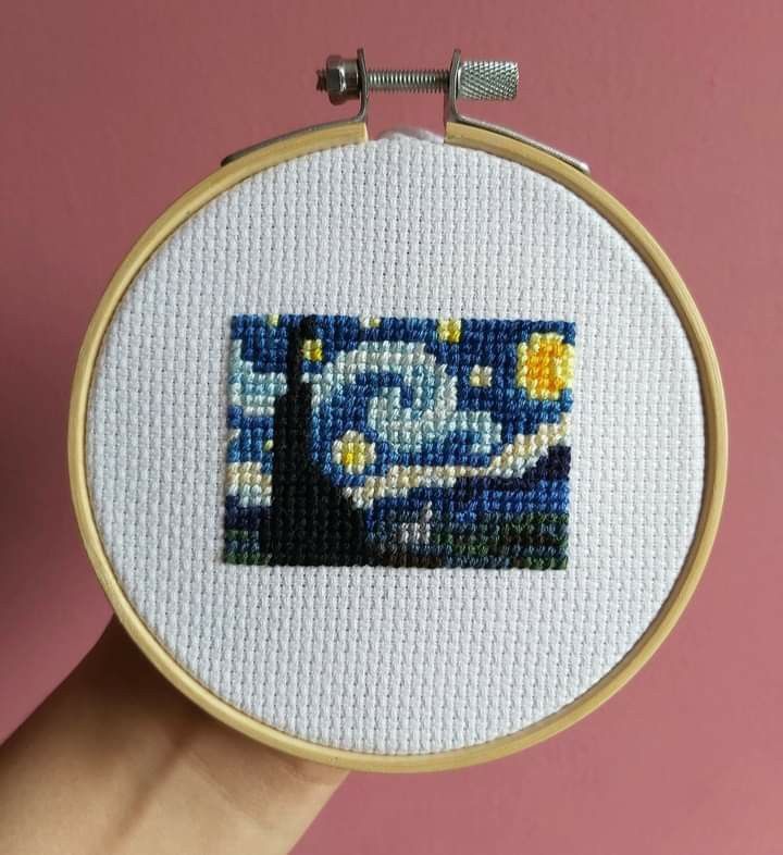 someone is holding up a cross - stitch art piece with the starry night painting on it