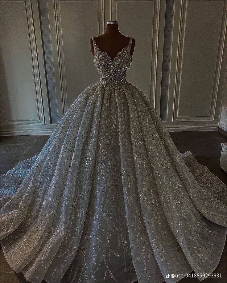 a ball gown is displayed on a mannequin stand in front of a white wall