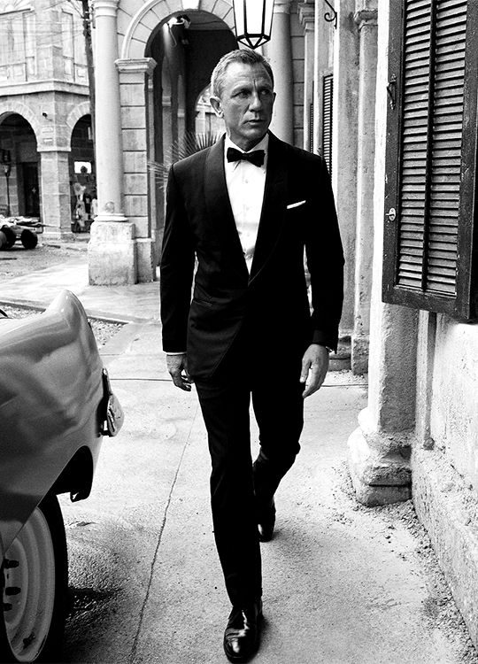 a man in a tuxedo is walking down the street