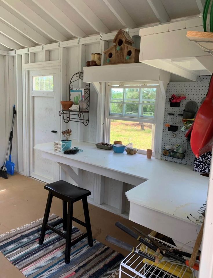 a room that has a desk and some chairs in it with shelves on the wall