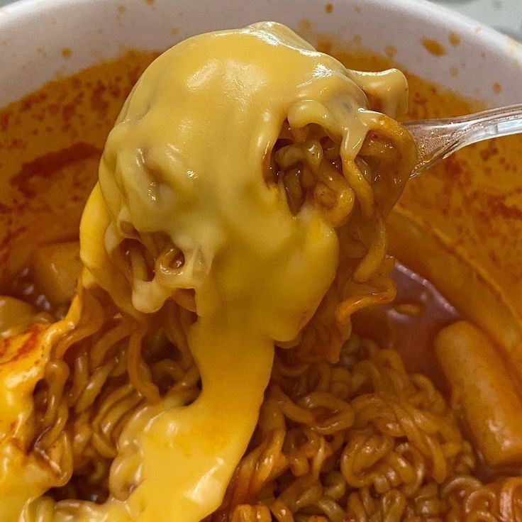 a spoon full of noodles with cheese on top