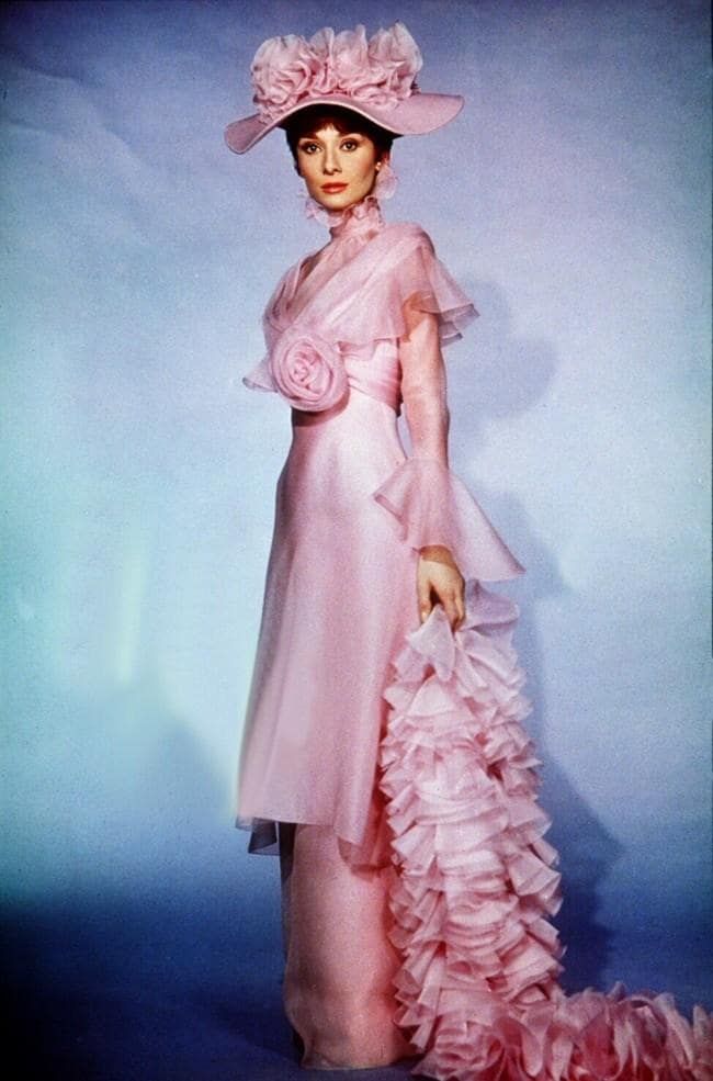 a woman in a pink dress and hat