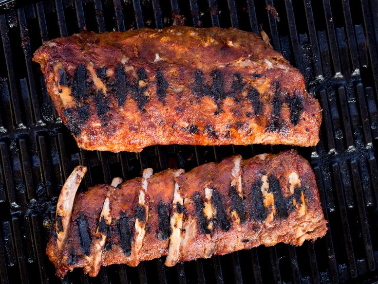 two steaks are cooking on the grill