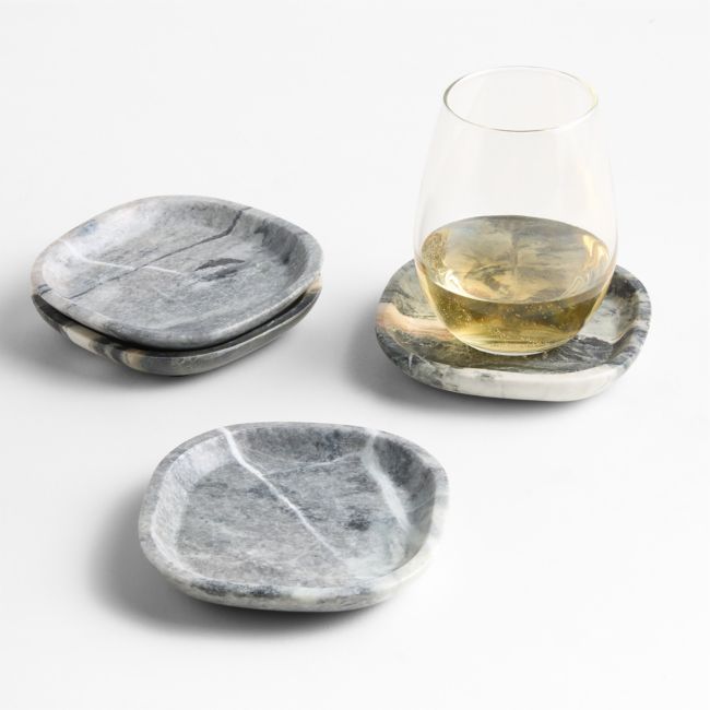 three marble coasters and a glass on a white surface