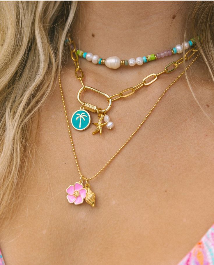 The Hibiscus Necklace is the necklace of the summer! The bright enamel Hibiscus charm paired with a gold conch shell on a ball chain is the perfect representation of the whimsical free spirit of summertime. 24k gold plated tarnish free 19” Cheap White Charm Necklaces For The Beach, Cheap Casual Summer Shell Necklace, Cheap Adjustable Necklaces With Starfish Charm, Summer Vibe Jewelry, Cheap Beachy Shell Necklace As A Gift, Luxury Shell-shaped Beach Necklaces, Cheap Playful Beach Necklaces, Preppy Gold Necklaces, Small Business Jewelry Photography