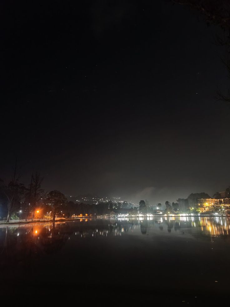 the night sky is lit up and reflecting in the water