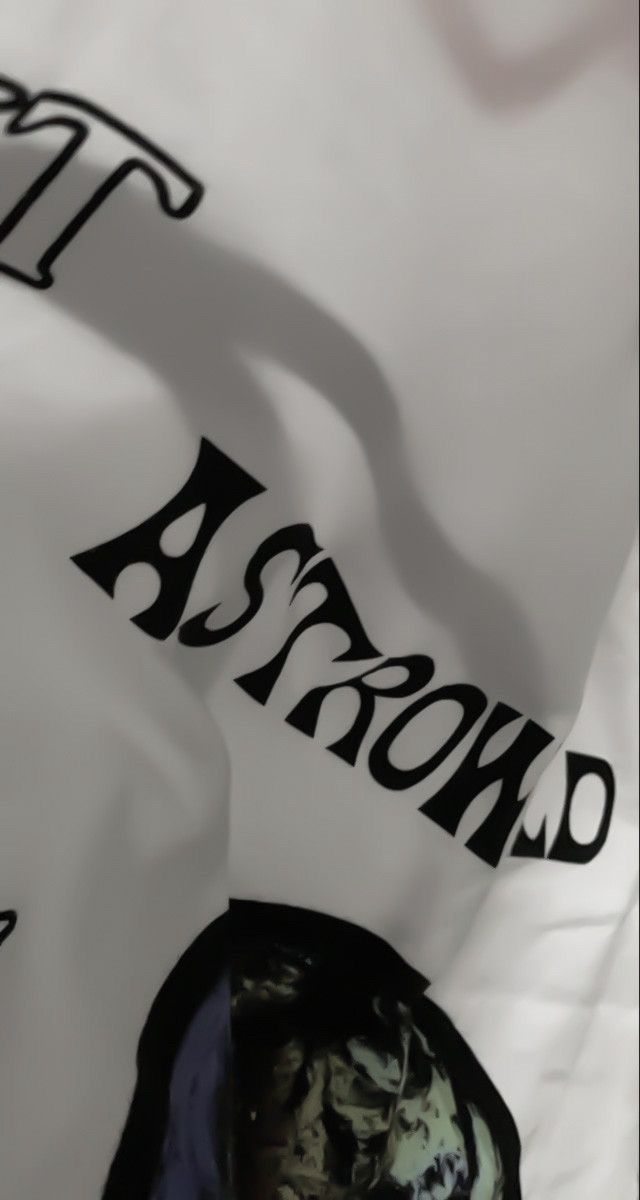 the shadow of a person's head on top of a white shirt with black writing