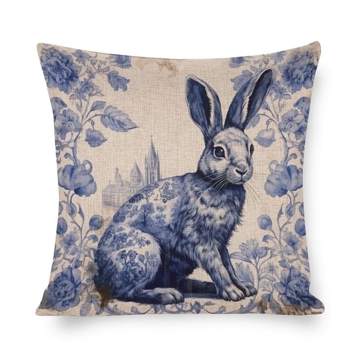 a blue and white pillow with an image of a rabbit sitting on top of it