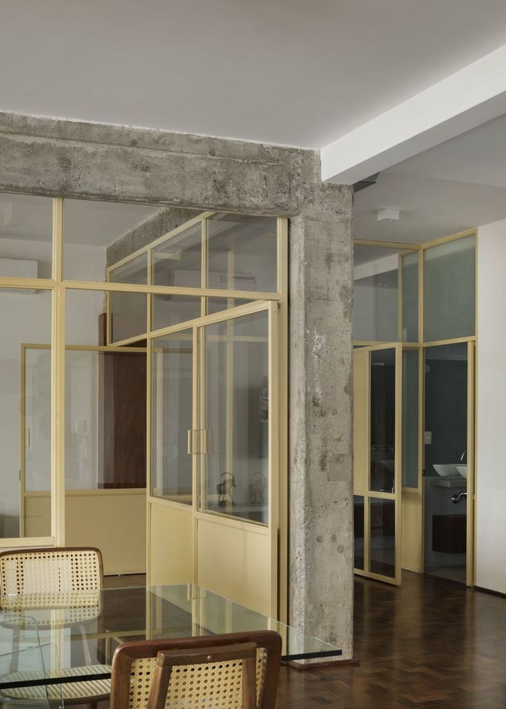 a table and chairs in a room with glass doors on the wall, and a person walking by