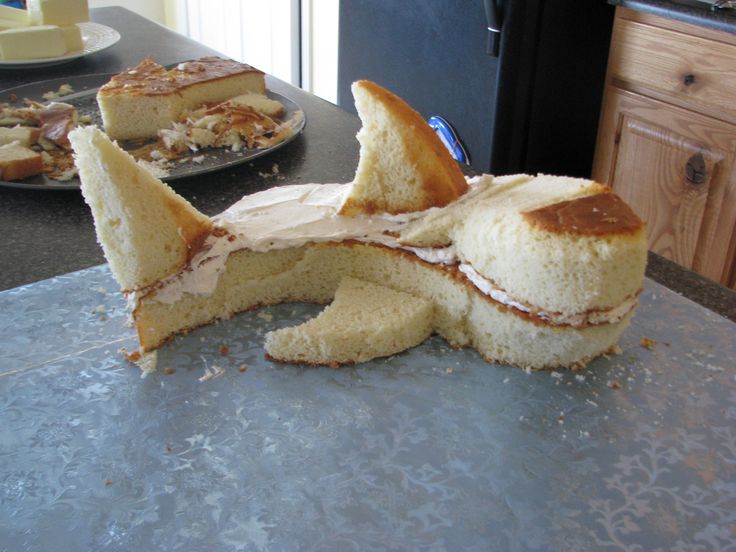 a sandwich cut in half sitting on top of a counter next to a plate of food