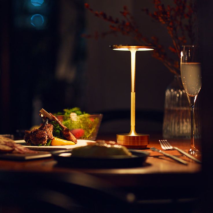 a table topped with plates and glasses next to a wine glass on top of a wooden table