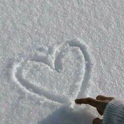 a person standing in the snow with a heart drawn on it