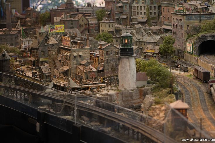 a model train set is shown in the middle of an urban area with buildings and trees