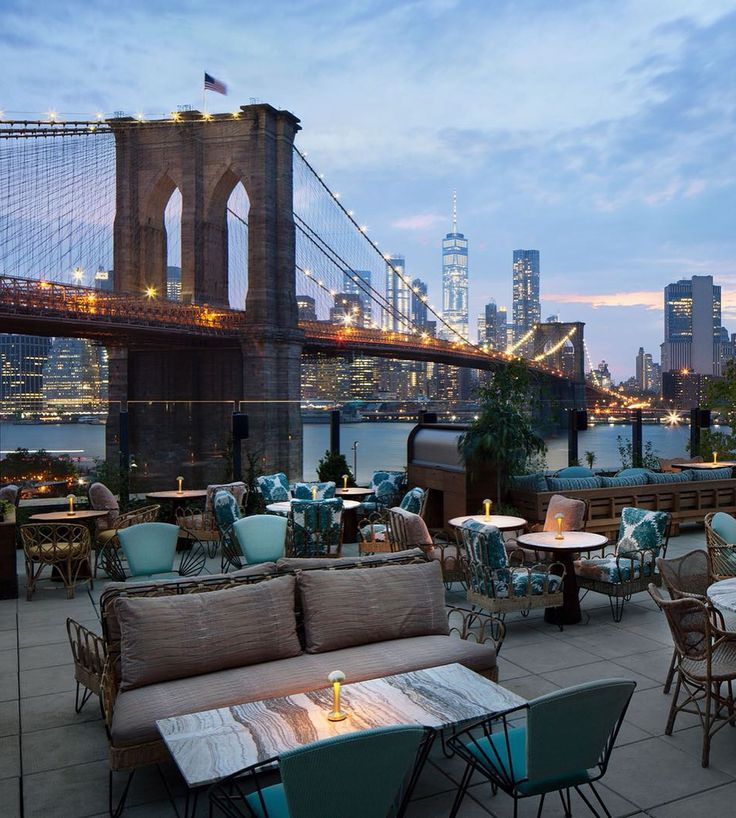 an outdoor dining area overlooking the brooklyn bridge