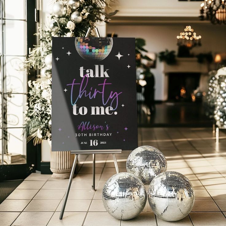 three disco balls sitting in front of a sign that says talk this time to me