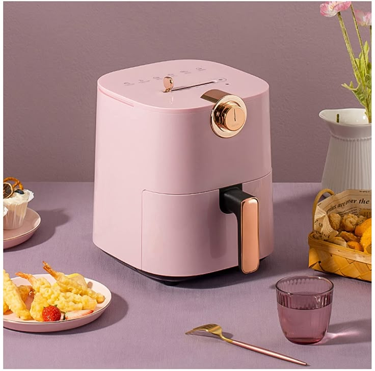 a pink toaster sitting on top of a table next to some plates of food