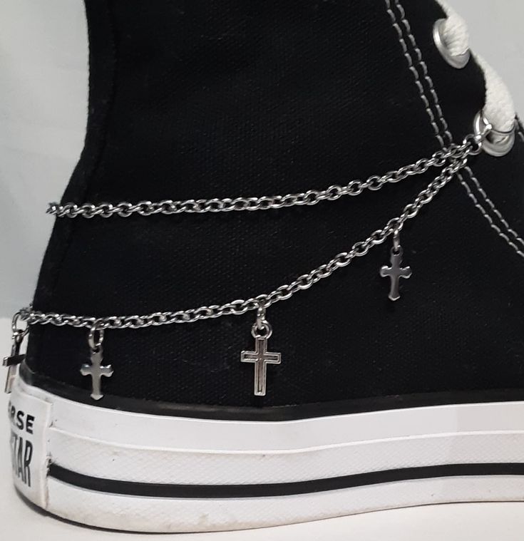 "This shoe or boot chain design features two chain strands with two styles of metal cross charms attached along the bottom chain. This design is available in Dark Silver (the chain is stainless steel). This listing is for 1 shoe (or boot) chain.  If you want chains for both shoes (or boots) you will need to order 2. There are 3 different ways to attach the chains to your shoe or boot. Below is the type of attachment and the length of each chain for that way. It is a good idea to measure your shoes or boots first to make sure the chain will fit. Jump Ring Ends to slip onto the laces - See picture 5. The length of the chain for this is 10 inches for shoes and 12 inches for boots or padded/thick high-tops. *The jump ring size for shoes are 8mm diameter and the jump ring size for boots are 10m Platform Boots With Chains, Edgy Leather Boots With Chain, Platform Boots Chains, Black Boots Chains, Boot Chains, High Top Shoe, Shoe Boot, Cross Chain, Metal Cross