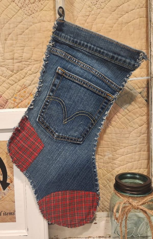 an old pair of jeans hanging on a wall next to a mason jar and framed photograph