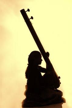 the silhouette of a woman sitting next to a musical instrument