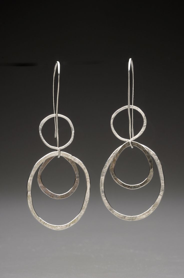 Silver Earrings - Kinetic, bold, and wonderfully lightweight, two hand-fabricated rings are suspended on an elongated Argentium silver ear wire. The floating center ring is oxidized and contrasts the bright, polished rings. Modern Jewelry With Oxidized Finish And Long Drop Shape, Modern Long Drop Jewelry With Oxidized Finish, Modern Hand Forged Hoop Earrings, Unique Silver Plated Wire Earrings, Modern Wire Wrapped Sterling Silver Earrings, Silver Plated Wire Drop Earrings, Handmade Silver Plated Wire Drop Earrings, Modern Hand-forged Silver Hoop Earrings, Contemporary Sterling Silver Hoop Earrings